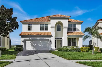 a white house with a garage at Windsor Hills Resort 6 Bedroom Private Pool Spa Home 0743 in Orlando