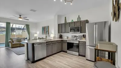 a kitchen with stainless steel appliances and a living room at Windsor Hills Resort 3 Bedroom Private Pool Townhome 0876 in Orlando