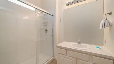 a white bathroom with a shower and a sink at Windsor Hills Resort 5 Bedroom Home with Game Room 0851 in Orlando