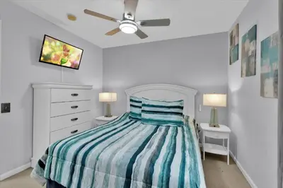 a bedroom with a bed with a striped comforter at Windsor Palms Resort 4 Bedroom with Game Room 0882 in Kissimmee