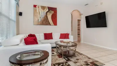 a living room with a white couch and a tv at Windsor Palms Resort 6 Bedroom with Game Room 0847 in Kissimmee