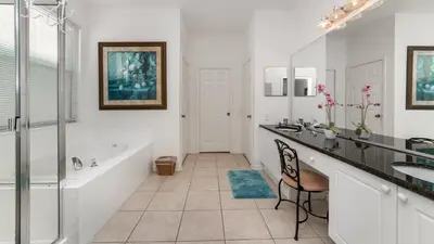 a bathroom with a tub and two sinks and a bath tub at Windsor Palms Resort 6 Bedroom with Pool Spa 0877 in Kissimmee