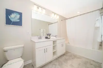 a bathroom with a toilet and a sink and a tub at Aconchegante 2Q no Storey Lake – 10 min da Disney! in Kissimmee