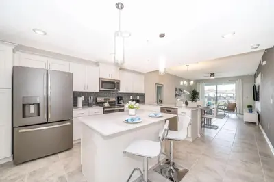 a kitchen with white cabinets and stainless steel appliances at Aconchegante 2Q no Storey Lake – 10 min da Disney! in Kissimmee