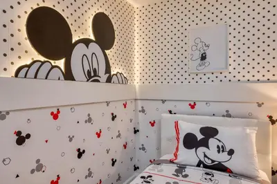 a bedroom with a bed with a mickey mouse wallpaper at Villa Luxuosa | 4 Quartos | Perto da Disney! in Orlando