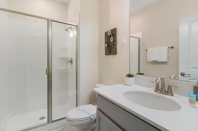 a white bathroom with a sink and a shower at Villa Kerpen - Storey Lake in Kissimmee