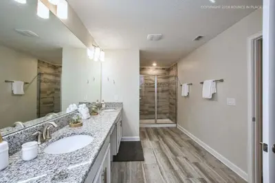 a bathroom with two sinks and a shower at Luxo Moderno | 5Q | Piscina | Perto da Disney in Kissimmee