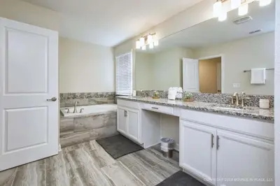 a white bathroom with a tub and a sink and a toilet at Luxo Moderno | 5Q | Piscina | Perto da Disney in Kissimmee