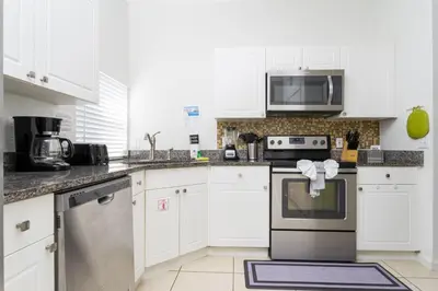 a kitchen with white cabinets and a stove top oven at Villa Helena, Windsor Palms in Kissimmee