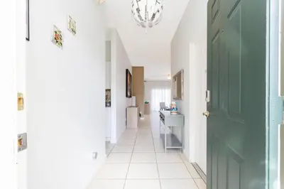 a hallway with a green door and a white tile floor at Villa Helena, Windsor Palms in Kissimmee