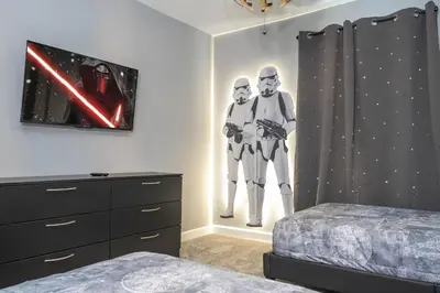 a bedroom with two men in costumes on the wall at Villa Smile, Storey Lake in Kissimmee