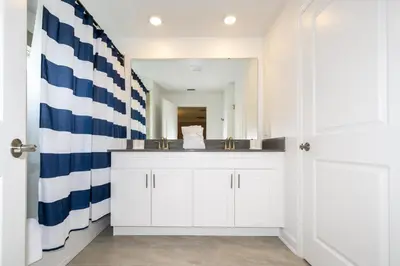 a bathroom with a sink and a large mirror at Villa Smile, Storey Lake in Kissimmee