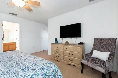 a bedroom with a bed and a tv and a chair at Villa Martins, Bella Vida in Kissimmee