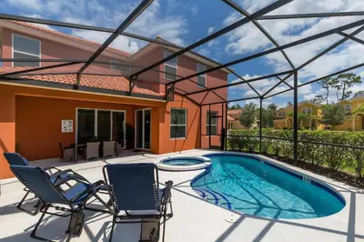 a patio with two chairs and a swimming pool at Villa Martins, Bella Vida in Kissimmee