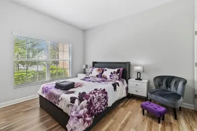 a bedroom with a bed and a chair at Lakefront 4 Bed private Oasis Location in Kissimmee
