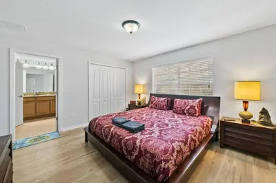 a bedroom with a bed with a red comforter at Lakefront 4 Bed private Oasis Location in Kissimmee