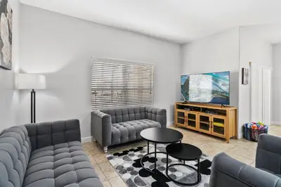 a living room with two couches and a tv at Lakefront 4 Bed private Oasis Location in Kissimmee