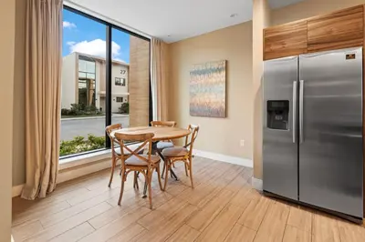 a kitchen with a table and a stainless steel refrigerator at 4BD and 4.5BA Amazing Villa with Private Hot Tub (3091) in Orlando