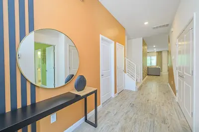 a hallway with a round mirror on the wall at Brand New 12BR Disney Mansion Pool Spa Game Room in Kissimmee