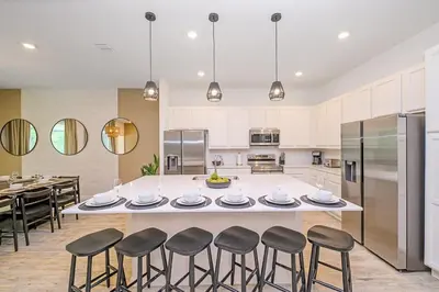 a kitchen with a large island with bar stools at Brand New 12BR Disney Mansion Pool Spa Game Room in Kissimmee