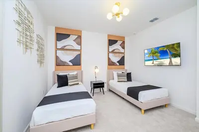 a bedroom with two beds and a ceiling fan at Brand New 12BR Disney Mansion Pool Spa Game Room in Kissimmee