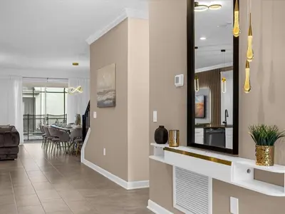 a living room with a mirror and a dining room at Brand New High End 9BR Villa in Storey Lake Resort in Kissimmee