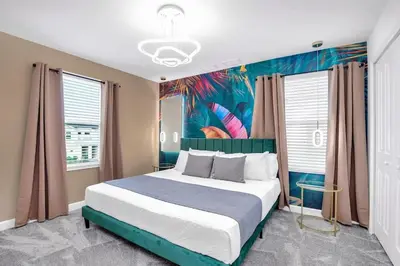 a bedroom with a large bed with a painting on the wall at Brand New High End 9BR Villa in Storey Lake Resort in Kissimmee