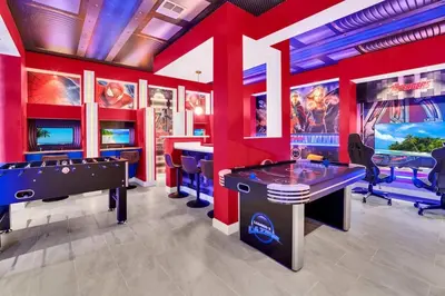 a gaming room with a pool table and arcade games at Brand New Luxury 9BR Villa Pool Spa Game Room in Kissimmee