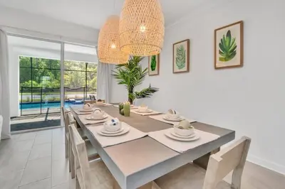 a white dining room with a table and chairs at Brand New Storey Lake 10 Bedroom Villa with Pool in Kissimmee
