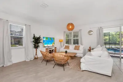 a living room with a white couch and chairs at Brand New Storey Lake 10 Bedroom Villa with Pool in Kissimmee