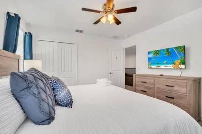 a bedroom with a bed and a ceiling fan at Brand New Storey Lake 10 Bedroom Villa with Pool in Kissimmee