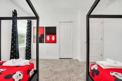 a bedroom with two beds and a mirror at Brand New Storey Lake 10 Bedroom Villa with Pool in Kissimmee