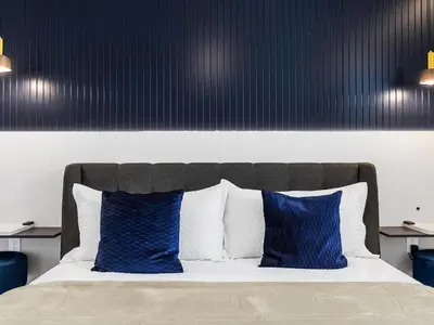 a bedroom with a bed with blue pillows at Brand New Storey Lake 9BR Villa Summer Kitchen in Kissimmee