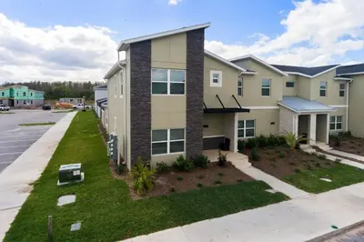 a apartment building with a lawn in front of it at 4184PD Weekly Stay 5BR Free Water Park in Kissimmee