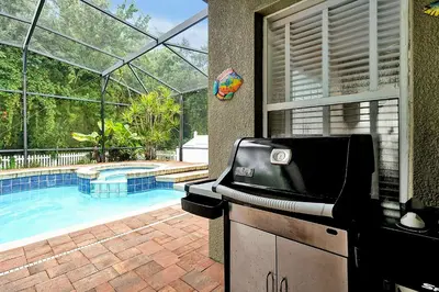 a kitchen with a grill and a swimming pool at 11326 CYPRESS TRAIL DRIVE ORLANDO 3BED in Orlando