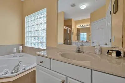 a bathroom with a sink and a large mirror at 11326 CYPRESS TRAIL DRIVE ORLANDO 3BED in Orlando