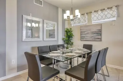 a dining room with a glass table and chairs at 3 Bed Condo Close to Disney at Storey Lake in Kissimmee