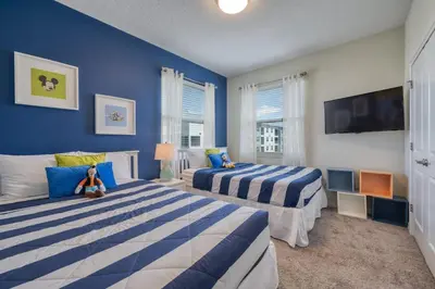 two beds in a bedroom with blue walls at 3 Bed Condo Close to Disney at Storey Lake in Kissimmee