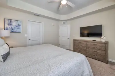 a bedroom with a bed and a flat screen tv at 3 Bed Condo Close to Disney at Storey Lake in Kissimmee