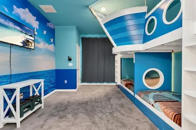 a bedroom with blue walls and a bunk bed with a boat on it at DeepSea World 15 Suites Sleep 30 Oversize Pool Spa in Kissimmee