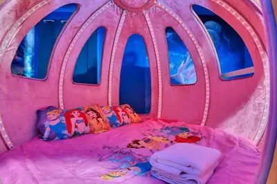 a pink bed in a room with windows at DeepSea World 15 Suites Sleep 30 Oversize Pool Spa in Kissimmee