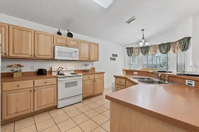 a large kitchen with wooden cabinets and white appliances at CLD4676 in Kissimmee