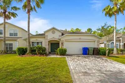 a house with palm trees and a driveway at CLD4676 in Kissimmee