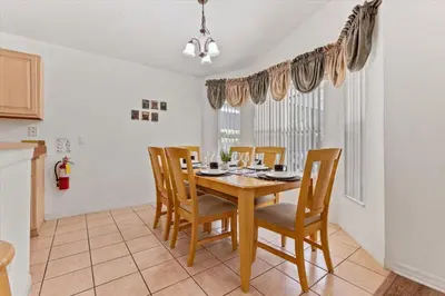 a dining room with a wooden table and chairs at CLD4676 in Kissimmee