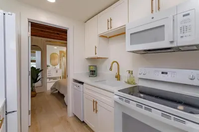 a kitchen with white cabinets and a sink at Hope House- Vacation Village 1 Bedroom with Loft in Clermont