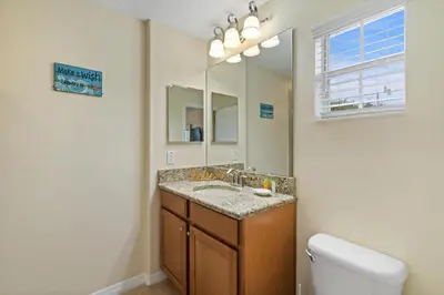 a bathroom with a sink and a mirror and a toilet at BCH3071 in Kissimmee