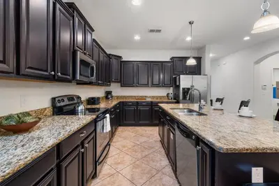 a kitchen with black cabinets and granite counter tops at CUP8931 in Kissimmee