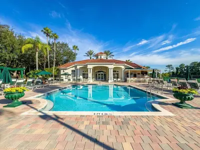 a swimming pool with chairs and a house at CCL8538 in Kissimmee