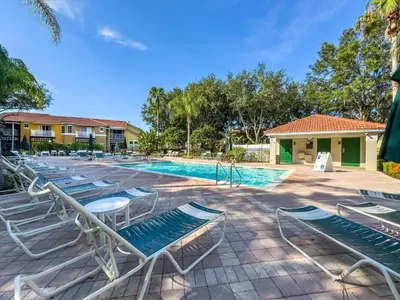 a swimming pool with lounge chairs next to a resort at CCL8538 in Kissimmee