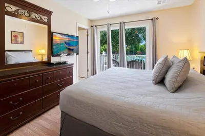 a bedroom with a bed and a television and a balcony at CCL8569 in Kissimmee